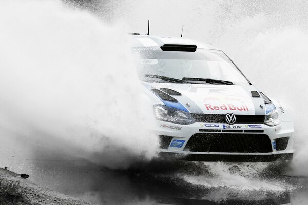 Volkswagen polo drives through a puddle at speed