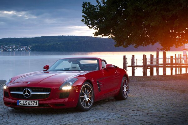 Schickes rotes Cabrio auf Wasserhintergrund