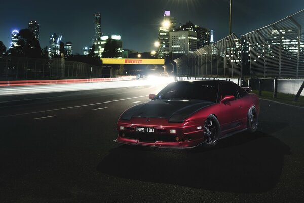 Samochód nissan 180SX na tle nocnego miasta