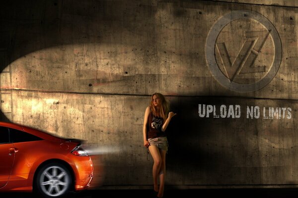 A girl against the wall against the background of a car