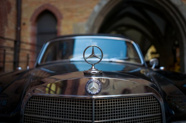 Mercedes badge on the hood of an old car