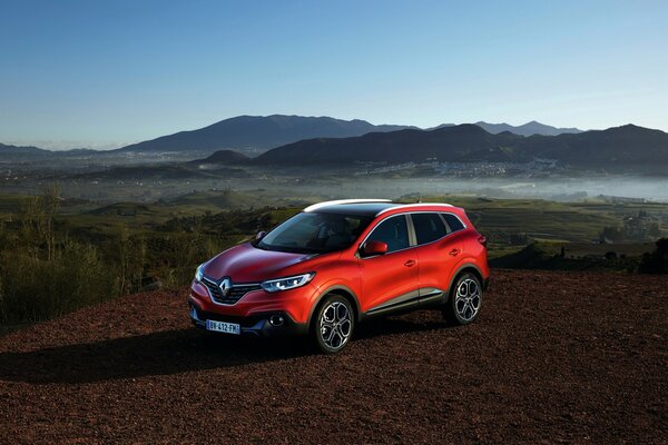 Roter Renault vor dem Hintergrund der Berge und des blauen Himmels