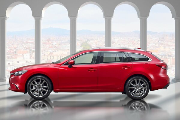 Rojo Mazda vagón en el fondo de la ciudad