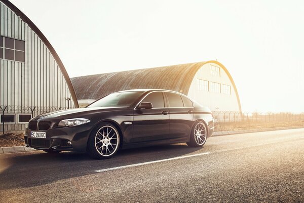 El coche negro de BMW se encuentra en la pista bajo el sol