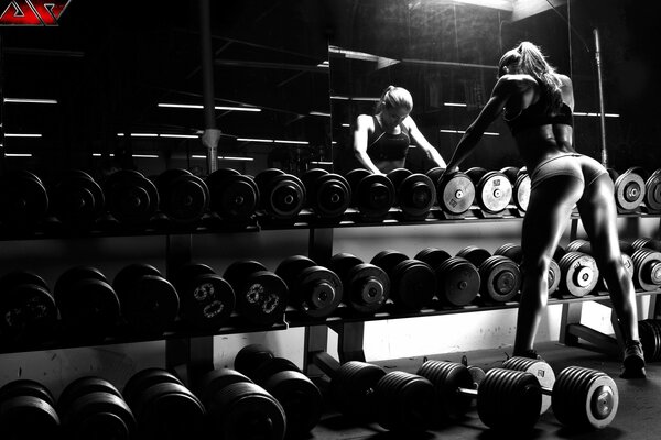 Chica en el gimnasio con mancuernas