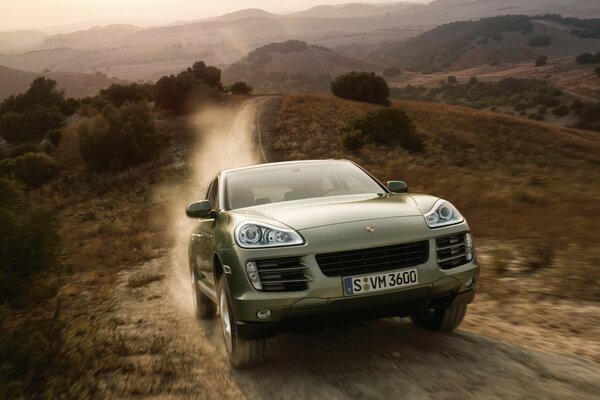 The SUV cuts through the dusty hills