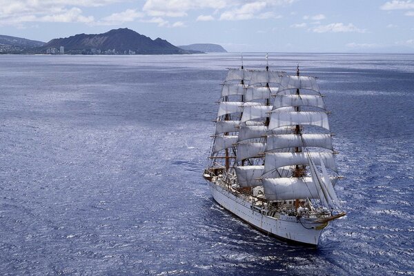 Un navire aux voiles blanches sillonne les vagues de l océan