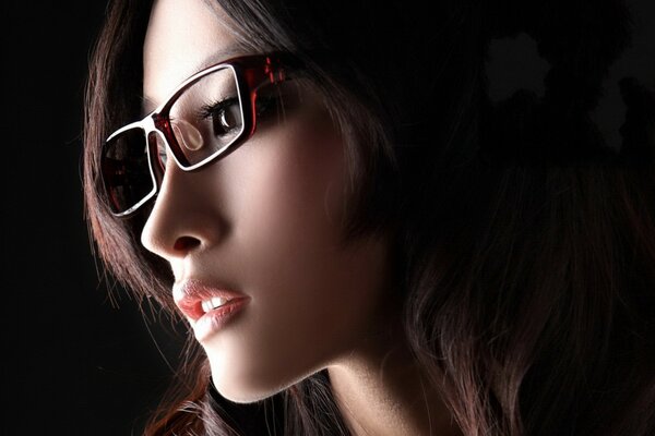 Asian girl with glasses on a black background