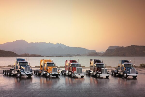 Camion potenti sullo sfondo del lago e delle montagne 