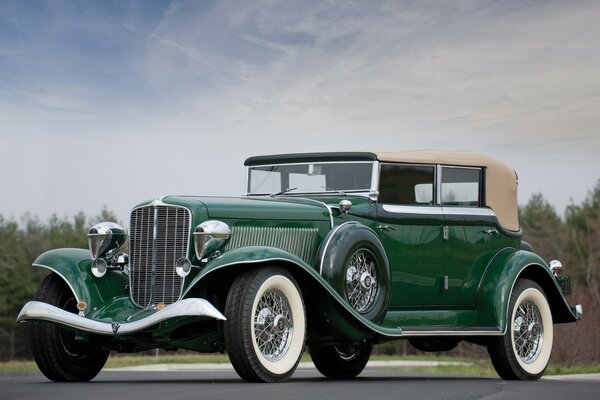 Coche retro verde con neumáticos blancos