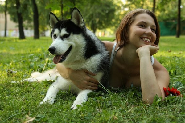 Mädchen mit Hund liegen auf dem Rasen