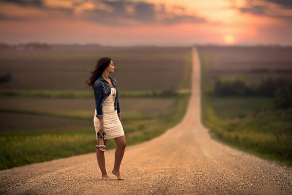 Ragazza a piedi nudi in attesa sta sulla strada