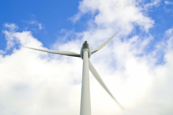 Aerogenerador de energía contra un cielo nublado