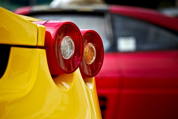 Two red headlights on a yellow car