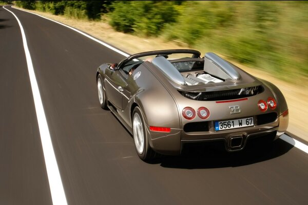 Cabrio fährt auf der Straße am Wald vorbei