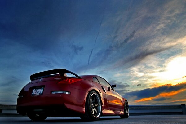 Roter Nissan vor dem Hintergrund eines schönen Sonnenuntergangs