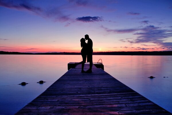 Pareja de enamorados besándose al atardecer