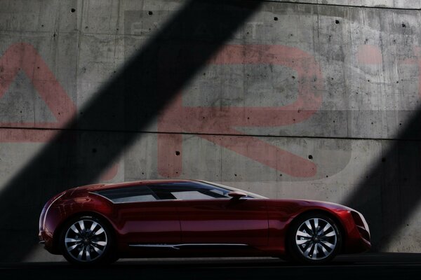 Voiture rouge sur fond de mur gris