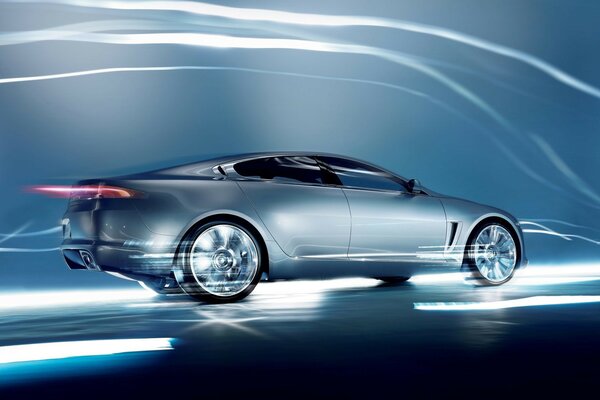 Jaguar c -xf drives at speed. Grey background with lightning bolts