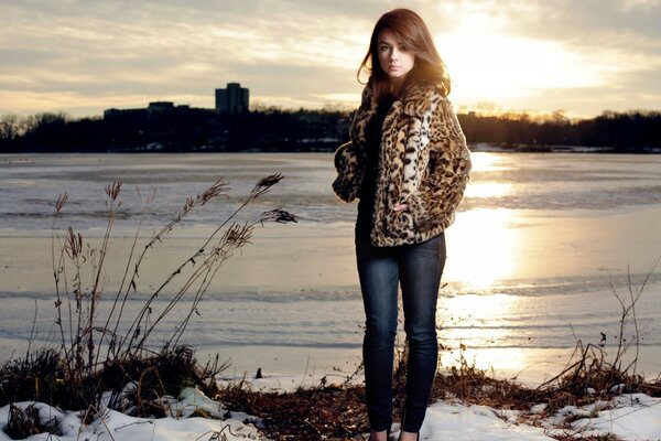 Hermosa chica en el río en invierno