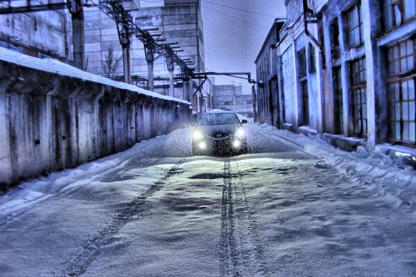 Winter landscape with a white Mazda that turned on the headlights