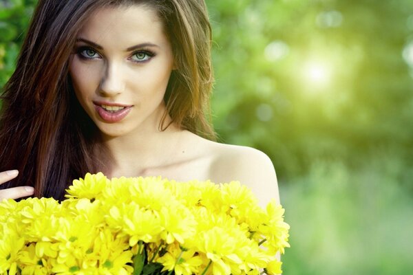 Beautiful woman with yellow flowers in her hands