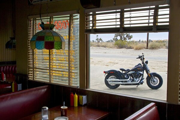 Schwarze harley davidson im fenster eines straßencafés