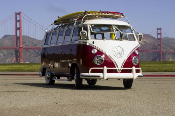 Ein rot-weißer Bus vor dem Hintergrund der berühmten Golden Gate Bridge. Netter heller VW-Marken-Bus