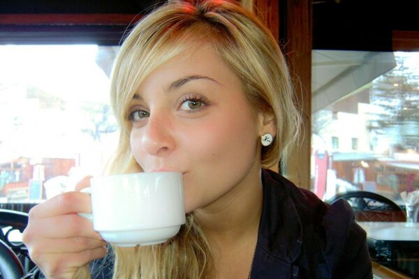 L attrice beve caffè. Istantanea in una caffetteria