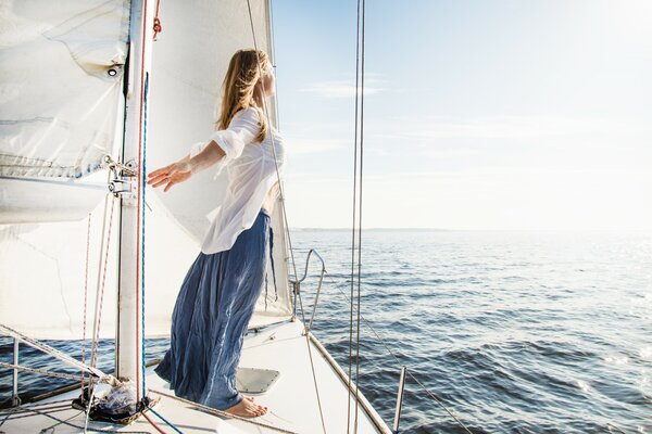 A girl on a yacht sails to meet the wind