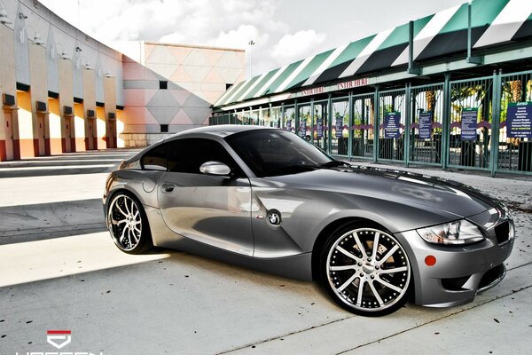 Foto de un BMW Z4 plateado en el fondo de los edificios