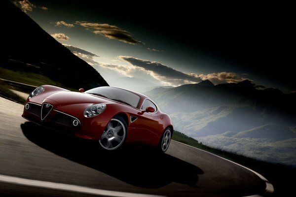 Red Alfa Romeo car on the road in the mountains