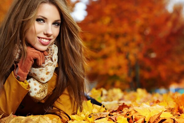 The brown-haired woman lay down on the golden foliage