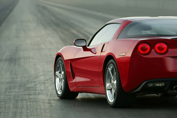 A red Chevrolet Corvette is parked on the road