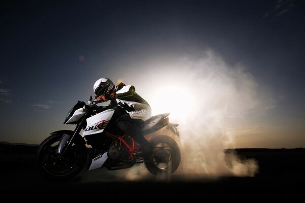 A motorcycle racer is racing at full speed in the night