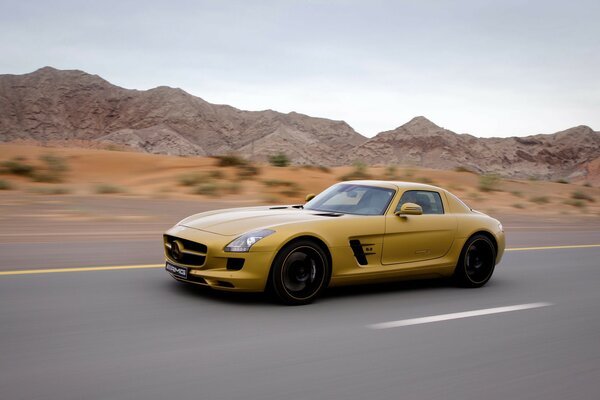 Желтый Mercedes-benz sls amg едет на большой скорости