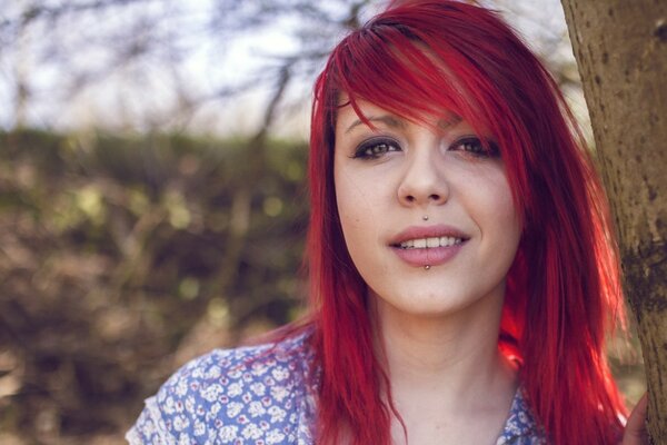 A red-haired girl. Portrait of a girl by a tree