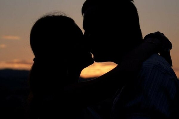 Romantyczny pocałunek na tle zachodzącego słońca
