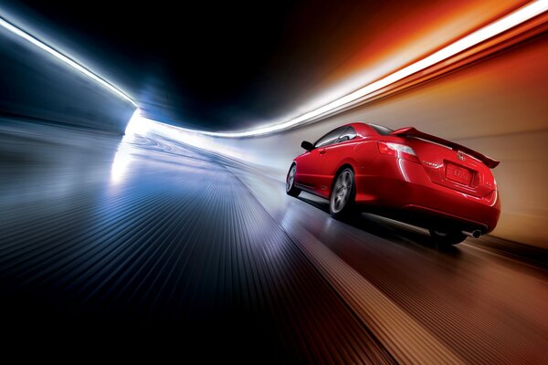 W tunelach czerwony samochód z dużą prędkością