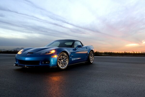 Blue car on sunset background