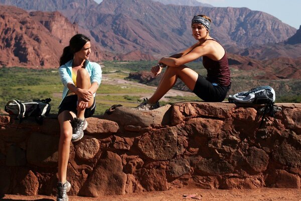 Two girls sat down to rest on the rocks. a fragment from the film