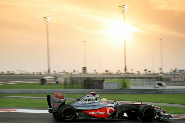 Auto di Formula Uno in pista al tramonto