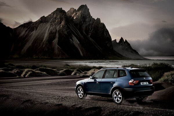 Bmw X3 bleu sur fond de montagnes et de l eau