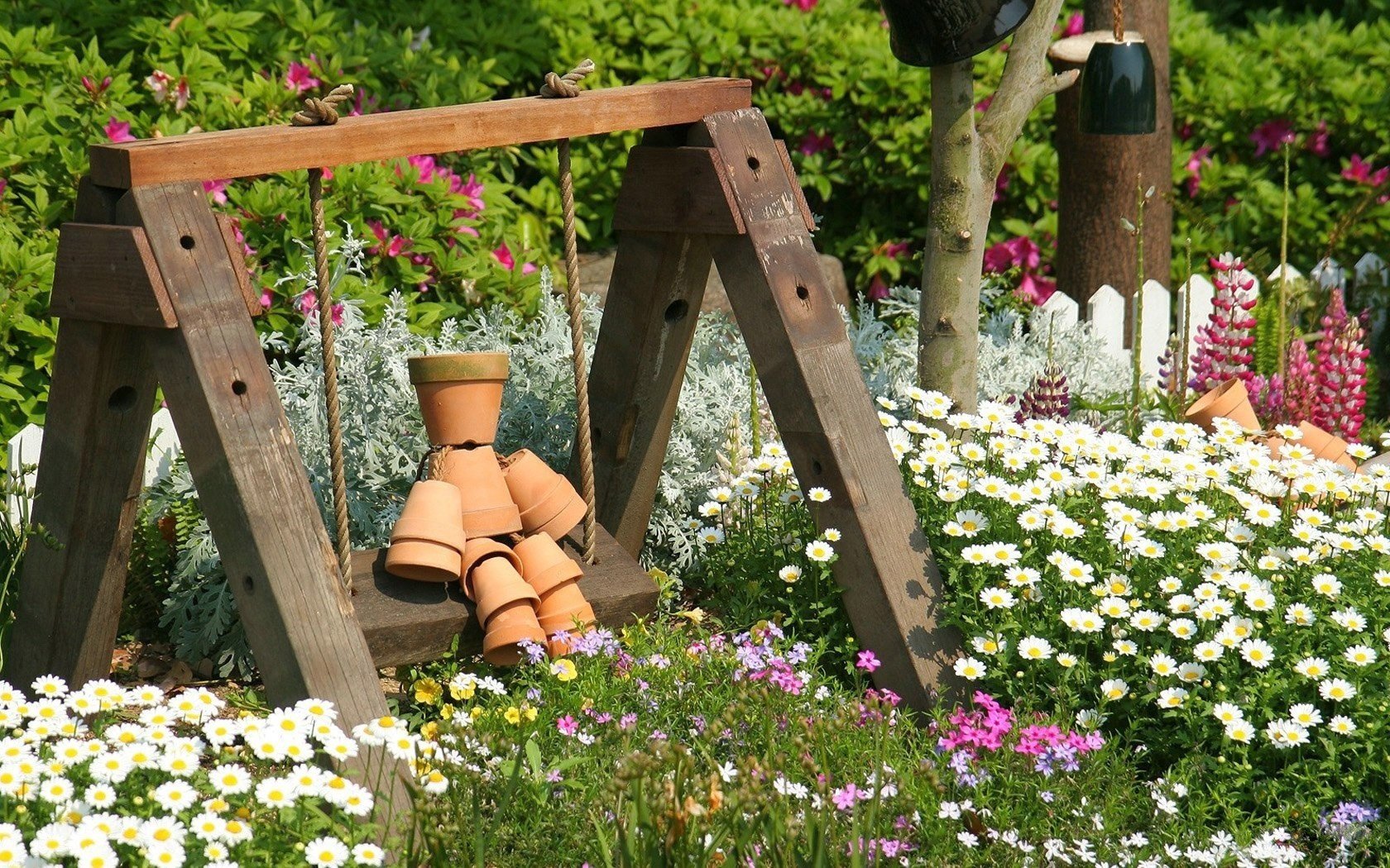 balançoire en bois fleurs clôture pots champ de marguerites pots champ été arbre marguerites herbe buissons