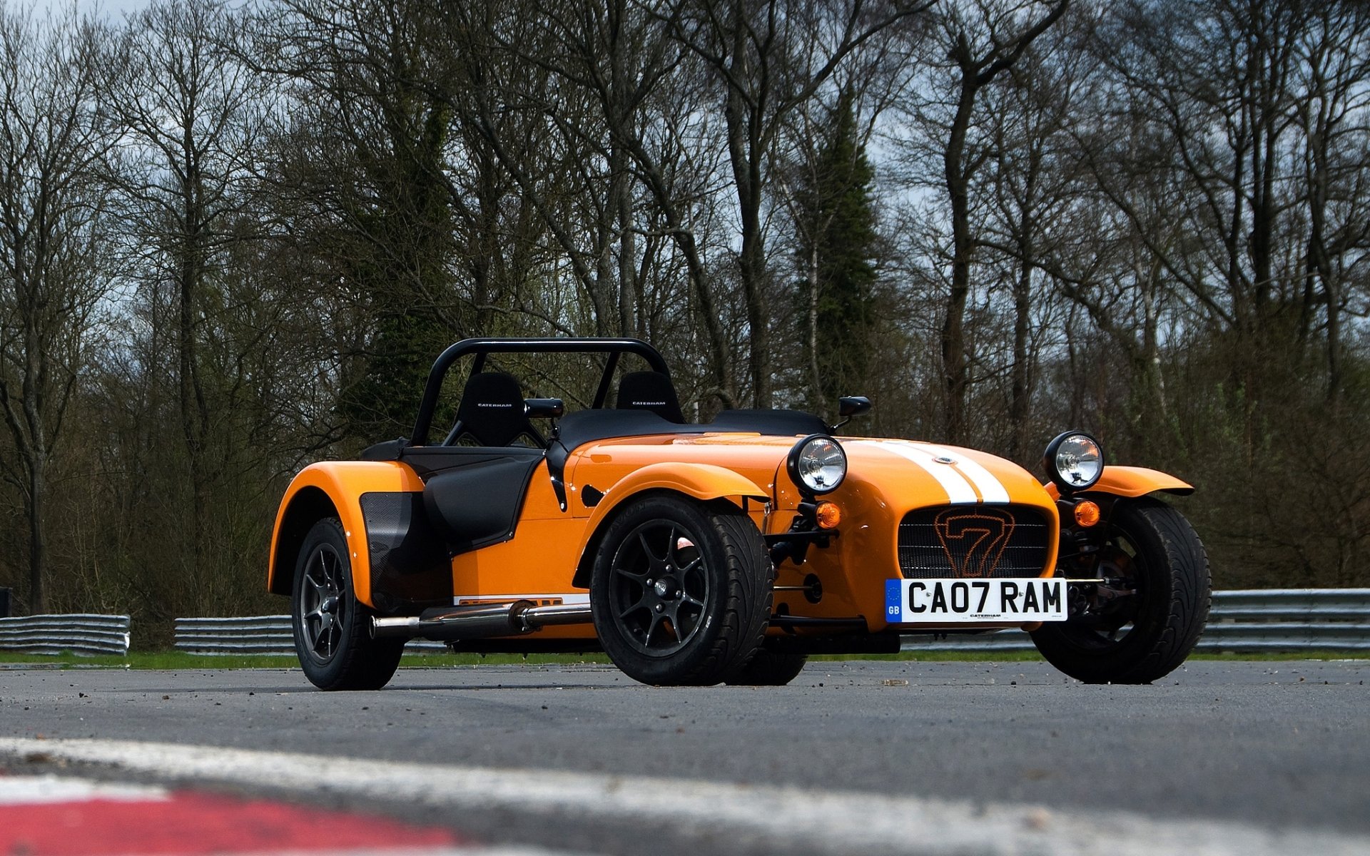 caterham seven supersport boat seven supercar orange front end race track trees background