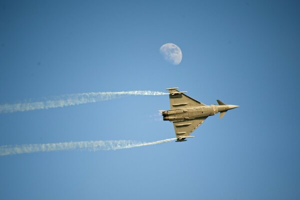 Fighter jet in the sky next to the moon