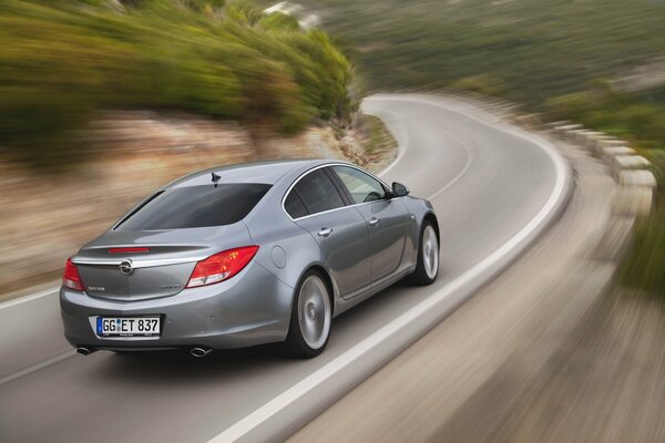 A gray Opel car rushes down the road