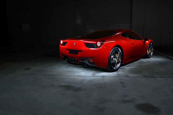 Красный автомобиль ferrari 458 italia заезжает в гараж