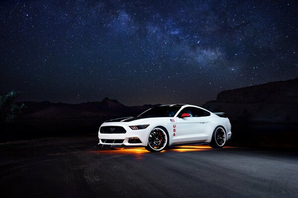 A white Ford Mustang on a starry sky background