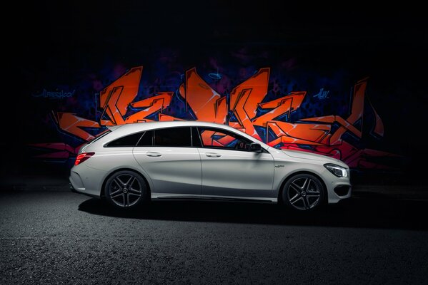 Weißer Mercedes amg cla 45 auf Graffiti-Hintergrund